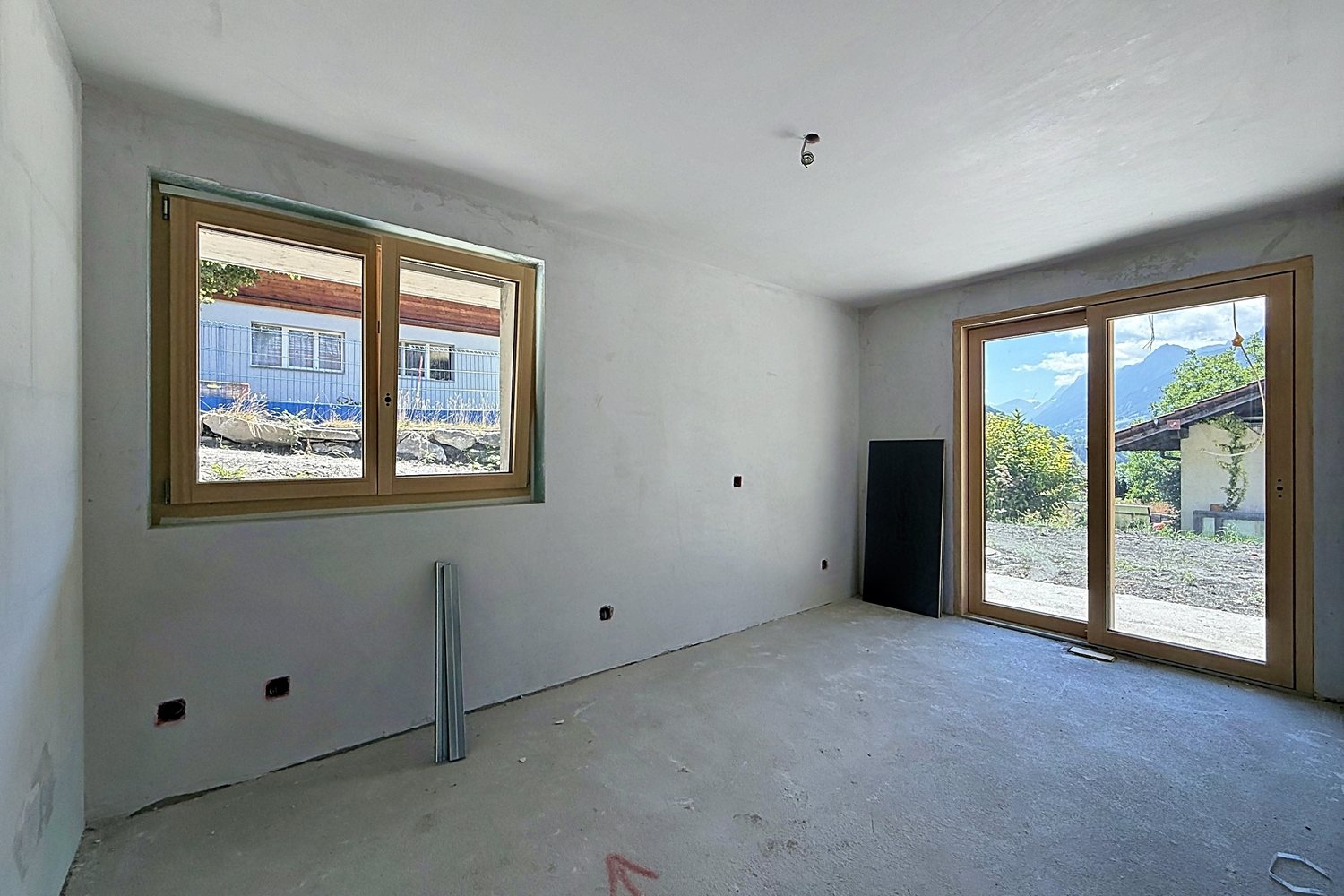 Chambre au rez-de-jardin avec porte-fenêtre sur l'extérieur.