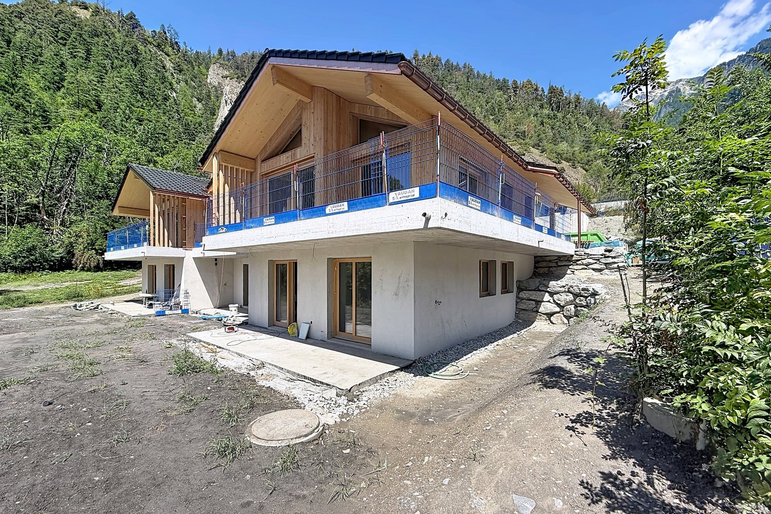 La villa en chantier vue depuis le jardin, échafaudages en place.