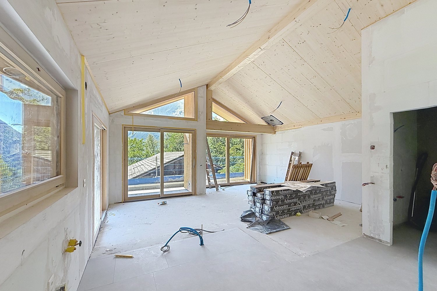 Volume de jour brut, plafond en bois et grandes baies.